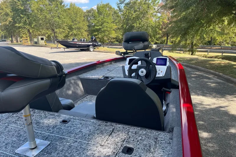 Slide: The Image of 2026 Tracker Pro Team 175 boat interior with steering wheel and seats, parked outdoors. - 5