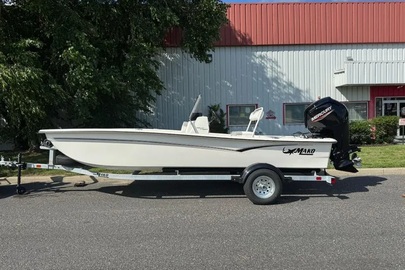Slide: The Image of 2026 Mako Pro Skiff 17 CC boat on trailer, parked outdoors. - 1