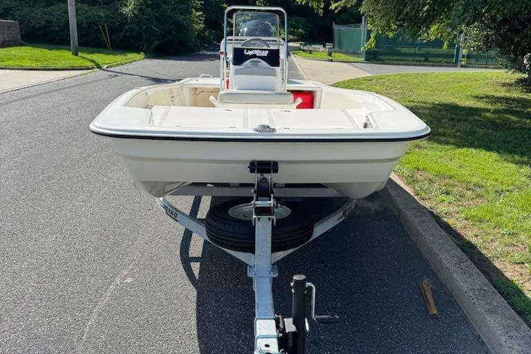 Slide: The Image of 2026 Mako Pro Skiff 17 CC boat on trailer, parked on a sunny street. - 4