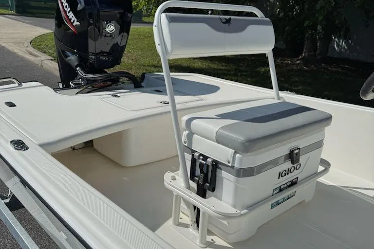 Slide: The Image of 2026 Mako Pro Skiff 17 CC boat interior with Igloo cooler seat and Mercury engine. - 7