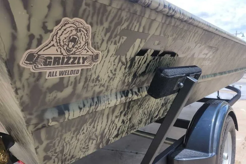 Slide: The Image of 2026 Tracker Grizzly 1860 Utility boat with camo design and "All Welded" logo. - 3