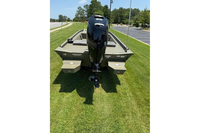 Slide: The Image of 2026 Tracker Grizzly 1860 Utility boat with outboard motor on grassy area. - 3