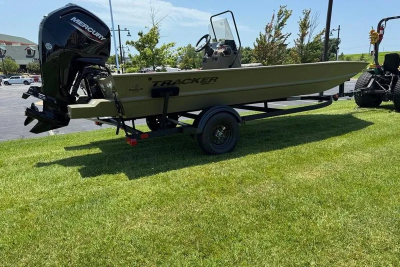 Slide: The Image of 2026 Tracker Grizzly 1860 Utility boat on trailer, parked on grass. - 7