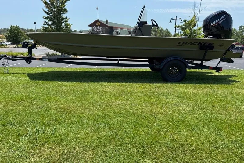 Slide: The Image of 2026 Tracker Grizzly 1860 Utility boat on trailer, parked on grass. - 9