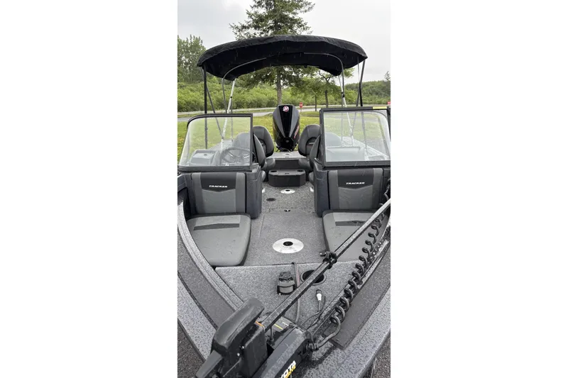 Slide: The Image of 2026 Tracker Targa V-18 Combo boat with seating and canopy, parked outdoors. - 2