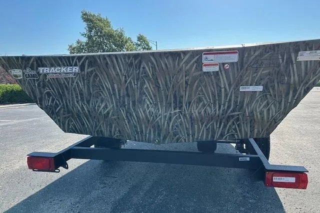 Slide: The Image of 2026 Tracker Grizzly 1648 Utility boat with camo design on a trailer. - 2