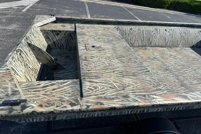 Slide: The Image of 2026 Tracker Grizzly 1648 Utility boat with camouflage pattern in a parking lot. - 3