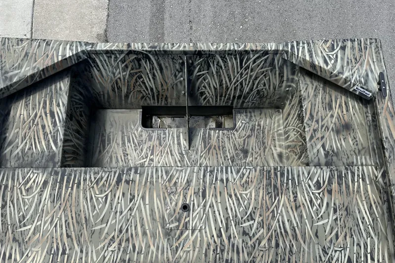 Slide: The Image of 2026 Tracker Grizzly 1648 Utility boat with camouflage pattern on a concrete surface. - 10