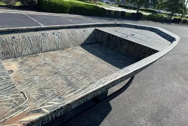 Slide: The Image of 2026 Tracker Grizzly 1648 Utility boat with camouflage pattern in a parking lot. - 4