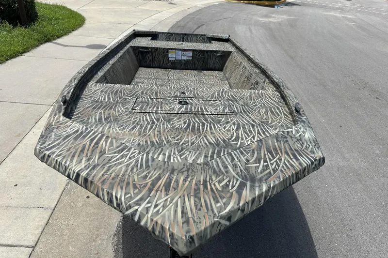 Slide: The Image of 2026 Tracker Grizzly 1648 Utility boat with camouflage design on a street. - 6