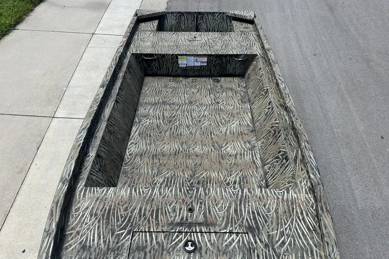 Slide: The Image of 2026 Tracker Grizzly 1648 Utility boat with camouflage pattern on pavement. - 7
