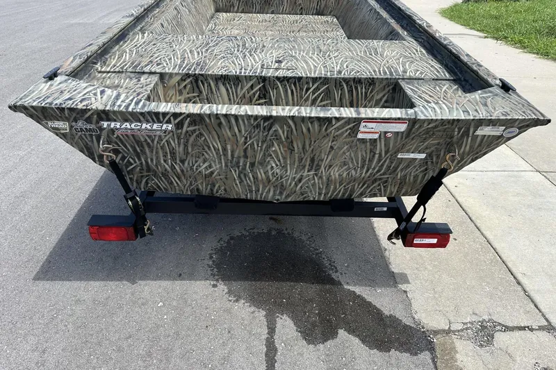 Slide: The Image of 2026 Tracker Grizzly 1648 Utility boat with camo design on a trailer. - 2