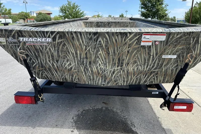 Slide: The Image of 2026 Tracker Grizzly 1648 Utility boat with camo design on a trailer. - 3