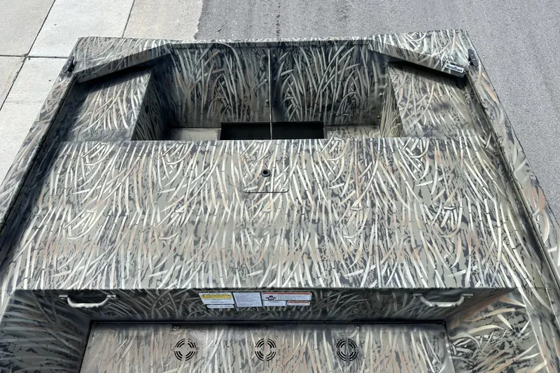 Slide: The Image of 2026 Tracker Grizzly 1648 Utility boat with camouflage pattern on pavement. - 9