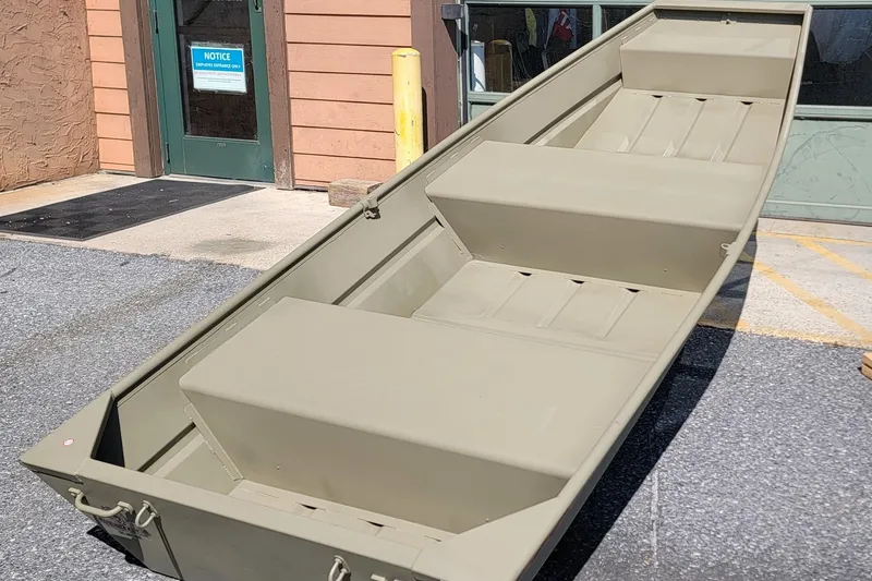 Slide: The Image of 2026 Tracker Grizzly 12 Jon boat in outdoor setting, showcasing its sturdy design. - 2