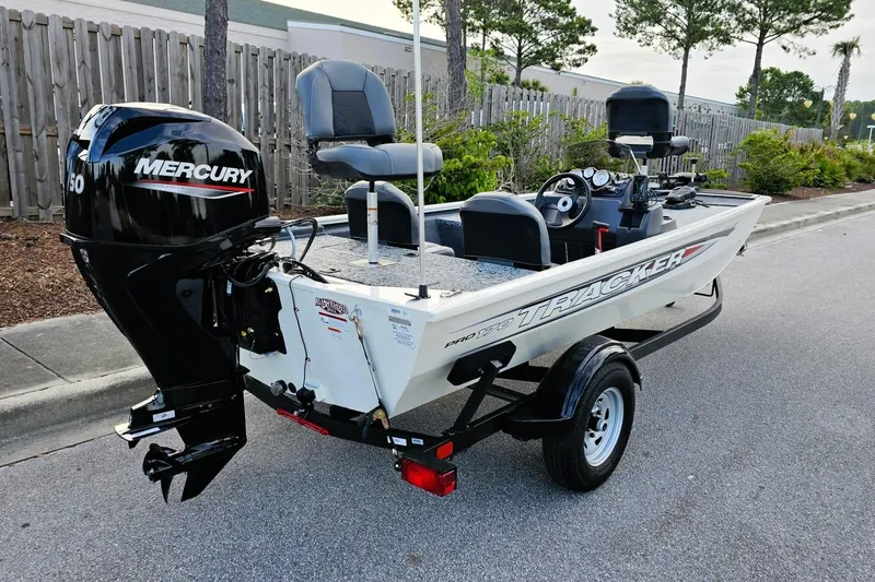Slide: The Image of 2026 Tracker Pro 170 boat with Mercury engine on a trailer, parked outdoors. - 2