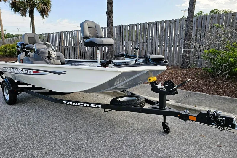 Slide: The Image of 2026 Tracker Pro 170 boat on trailer, parked outdoors near a wooden fence. - 5
