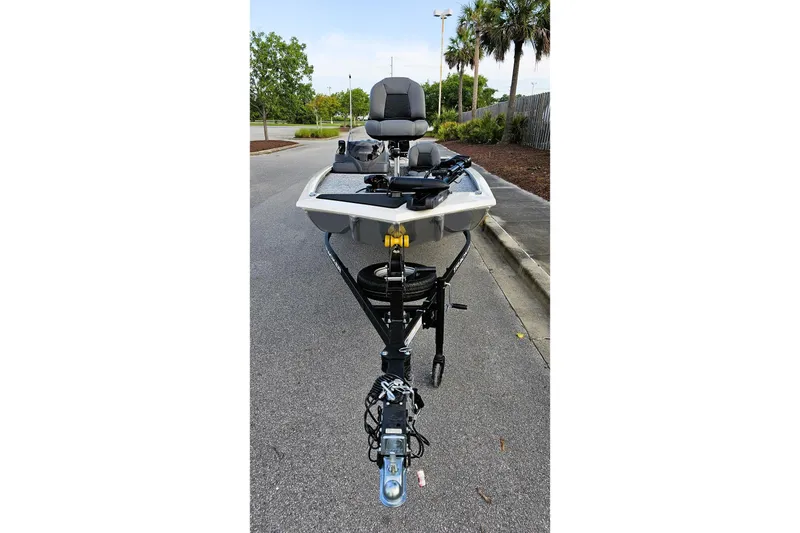 Slide: The Image of 2026 Tracker Pro 170 boat on trailer, parked on asphalt, surrounded by trees. - 7