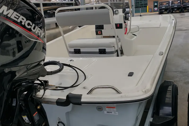 Slide: The Image of 2026 Mako Pro Skiff 17 CC boat with Mercury engine, featuring spacious seating and modern design. - 2