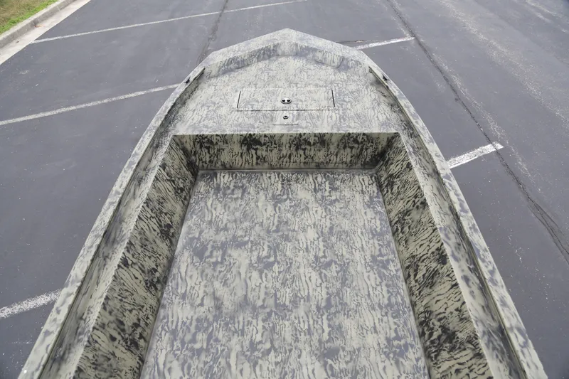 Slide: The Image of 2026 Tracker Grizzly 1648 Utility boat with camouflage pattern in a parking lot. - 2