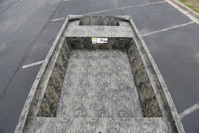 Slide: The Image of 2026 Tracker Grizzly 1648 Utility boat with camouflage interior, parked on asphalt. - 3