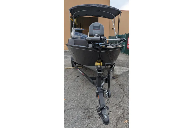 Slide: The Image of 2026 Tracker Pro Guide V-16 SC boat with canopy, parked on a trailer. - 2