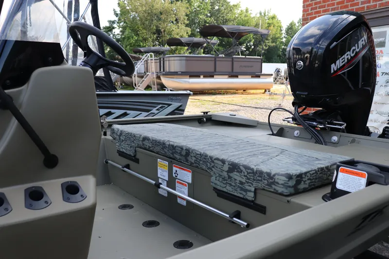 Slide: The Image of 2026 Tracker Grizzly 1860 CC boat interior with Mercury engine, camo seating, and steering wheel. - 9