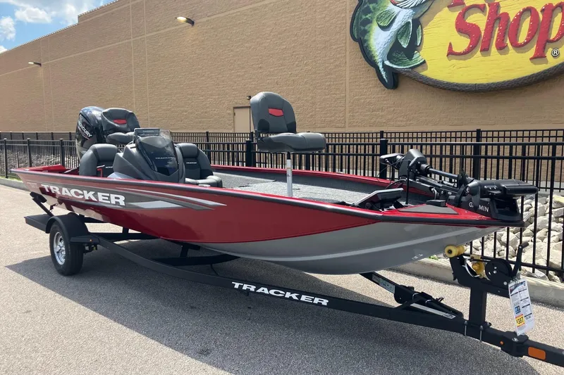Slide: The Image of 2026 Tracker Pro Team 190 boat in red, parked outside a shop on a trailer. - 2