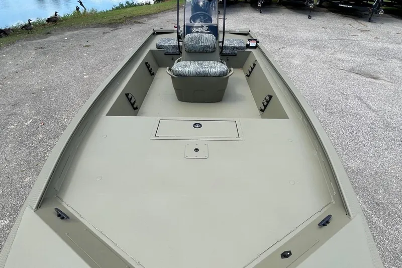 Slide: The Image of 2026 Tracker Grizzly 1860 CC boat with spacious deck and seating, parked near water. - 59