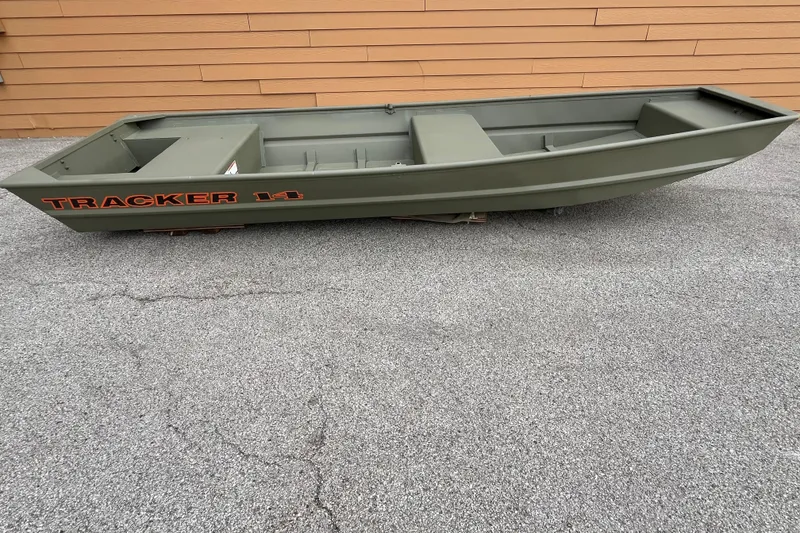 The Image of 2026 Tracker Grizzly 14 Jon boat on pavement, olive green with orange lettering. - 0
