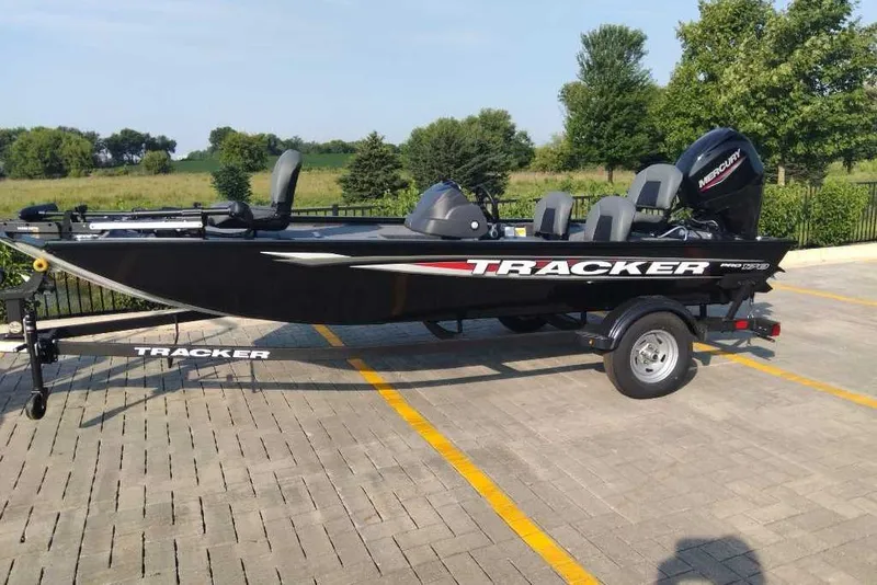 The Image of 2026 Tracker Pro 170 boat on trailer in parking lot, surrounded by greenery. - 0