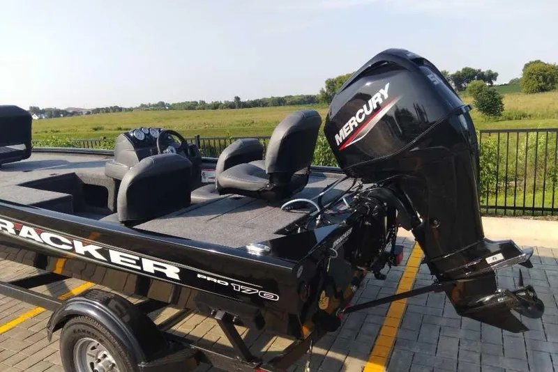Slide: The Image of 2026 Tracker Pro 170 boat with Mercury outboard motor, parked on paved area. - 3