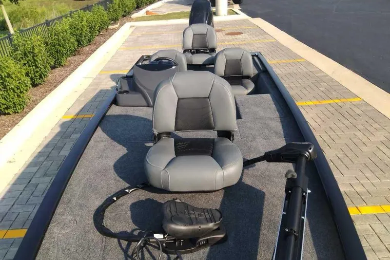 Slide: The Image of 2026 Tracker Pro 170 boat with gray seating, parked on a paved area. - 5