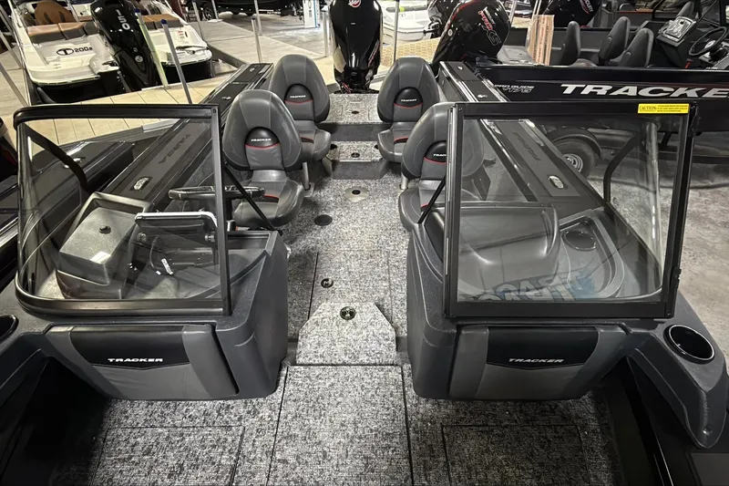 Slide: The Image of 2026 Tracker Targa V-18 WT boat interior with seating and windshield in showroom. - 2