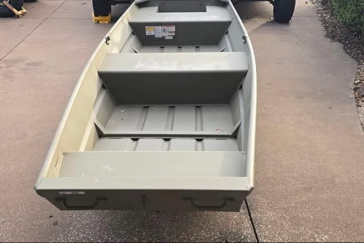 Slide: The Image of 2026 Tracker Grizzly 14 Jon boat on pavement, showcasing interior seating and design. - 2