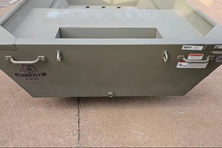 Slide: The Image of 2026 Tracker Grizzly 14 Jon boat, rear view, on concrete surface. - 3