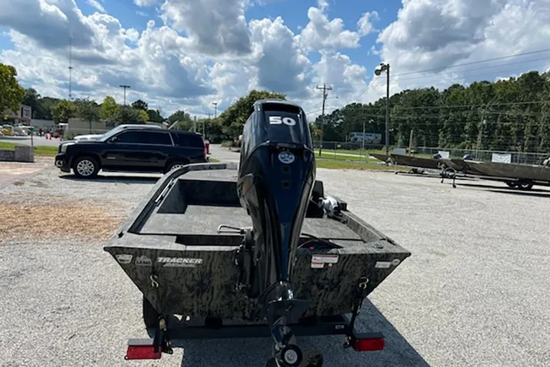 Slide: The Image of 2026 Tracker Grizzly 1648 SC boat with 50 HP motor in a parking lot. - 4