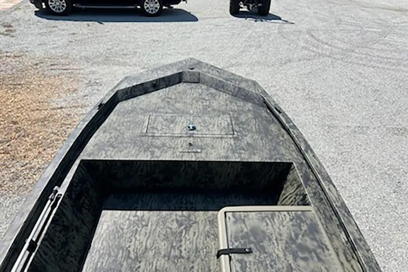 Slide: The Image of 2026 Tracker Grizzly 1648 SC boat with camouflage design on a gravel surface. - 8