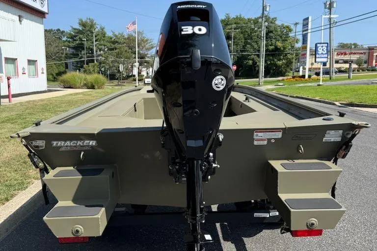 Slide: The Image of 2026 Tracker Grizzly 1654 T Sportsman boat with Mercury 30 engine, parked outdoors. - 3