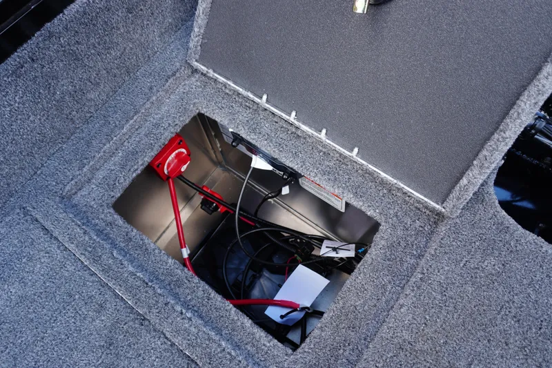 Slide: The Image of 2026 Tracker Targa V-18 WT boat storage compartment with wiring and red switch. - 20