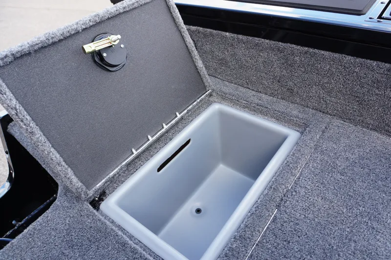 Slide: The Image of 2026 Tracker Targa V-18 WT boat storage compartment with open lid, gray interior. - 22