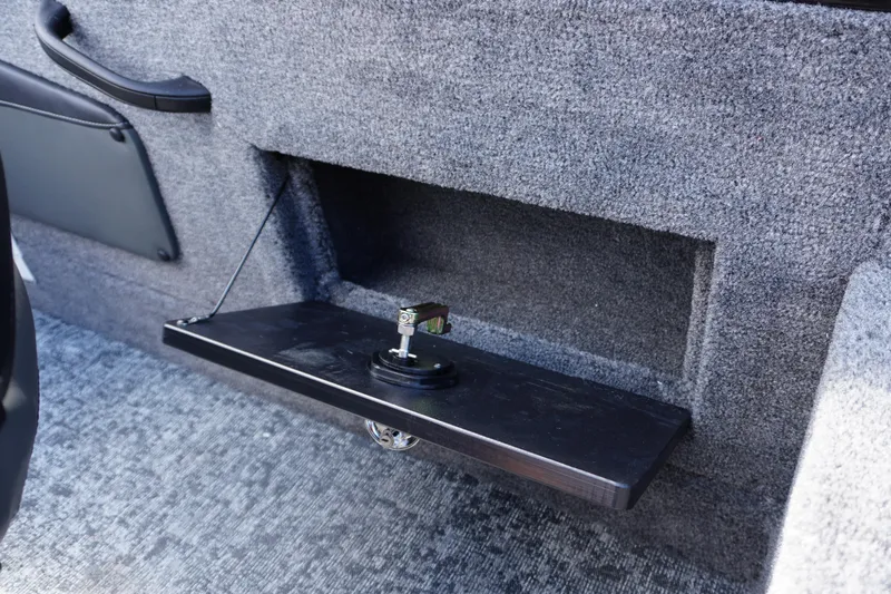 Slide: The Image of 2026 Tracker Targa V-18 WT interior storage compartment with foldable shelf. - 27