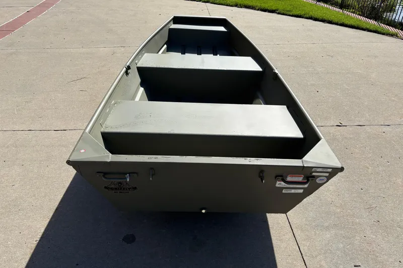 Slide: The Image of 2026 Tracker Grizzly 12 Jon boat on concrete surface, showcasing sturdy design and seating. - 2