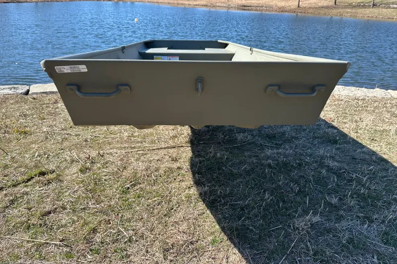 Slide: The Image of 2026 Tracker Grizzly 15 Jon boat on grassy shore by a lake. - 4