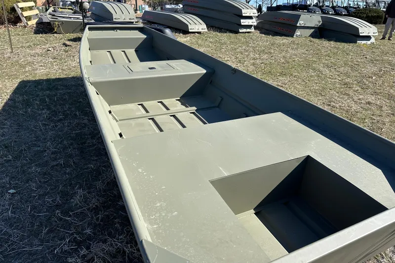 Slide: The Image of 2026 Tracker Grizzly 15 Jon boat on grassy field, showcasing spacious interior design. - 8