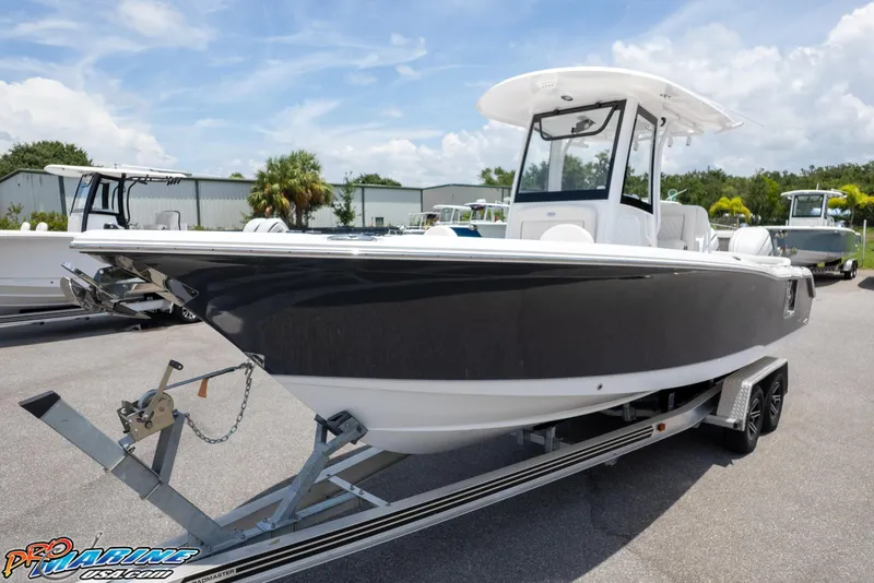 Slide: The Image of 2026 Sea Hunt Ultra 265 SE boat on trailer, parked outdoors under a clear sky. - 1