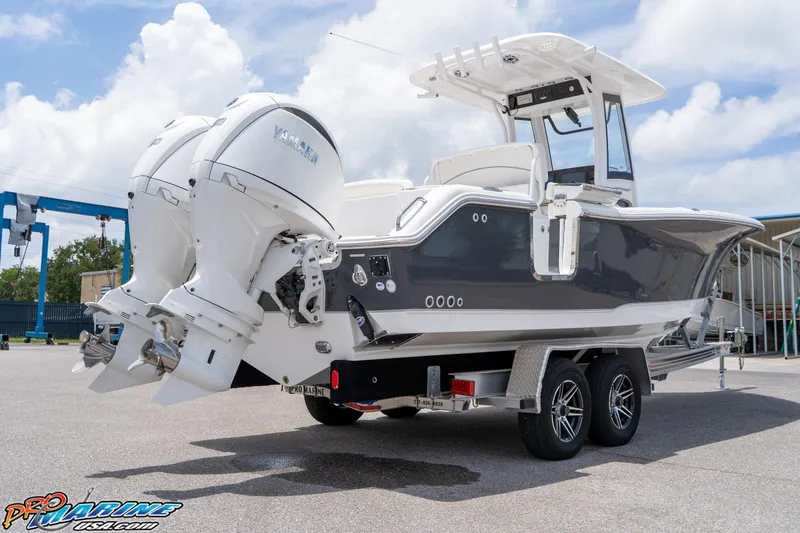 Slide: The Image of 2026 Sea Hunt Ultra 265 SE boat on trailer with dual Yamaha engines, parked outdoors. - 16