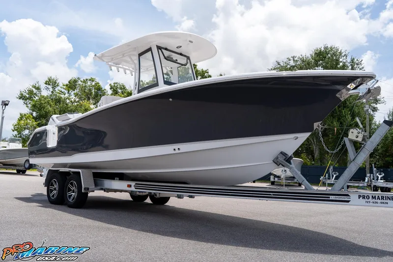 Slide: The Image of 2026 Sea Hunt Ultra 265 SE boat on trailer, parked outdoors under a cloudy sky. - 17