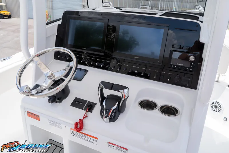 Slide: The Image of 2026 Sea Hunt Ultra 265 SE boat dashboard with steering wheel, dual screens, and controls. - 27