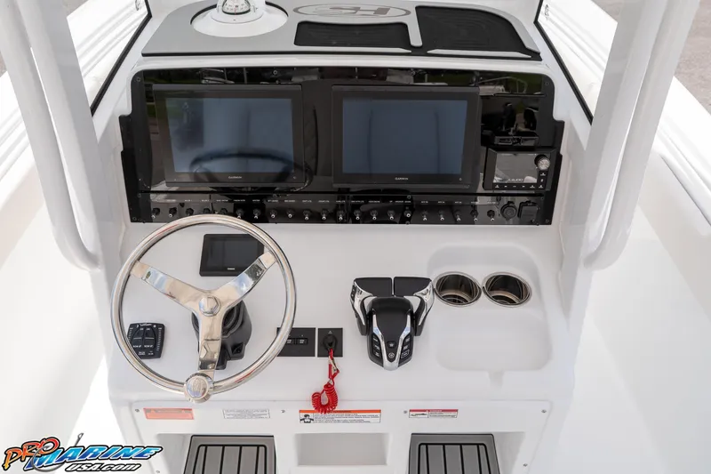 Slide: The Image of 2026 Sea Hunt Ultra 265 SE boat dashboard with dual screens and steering wheel. - 28